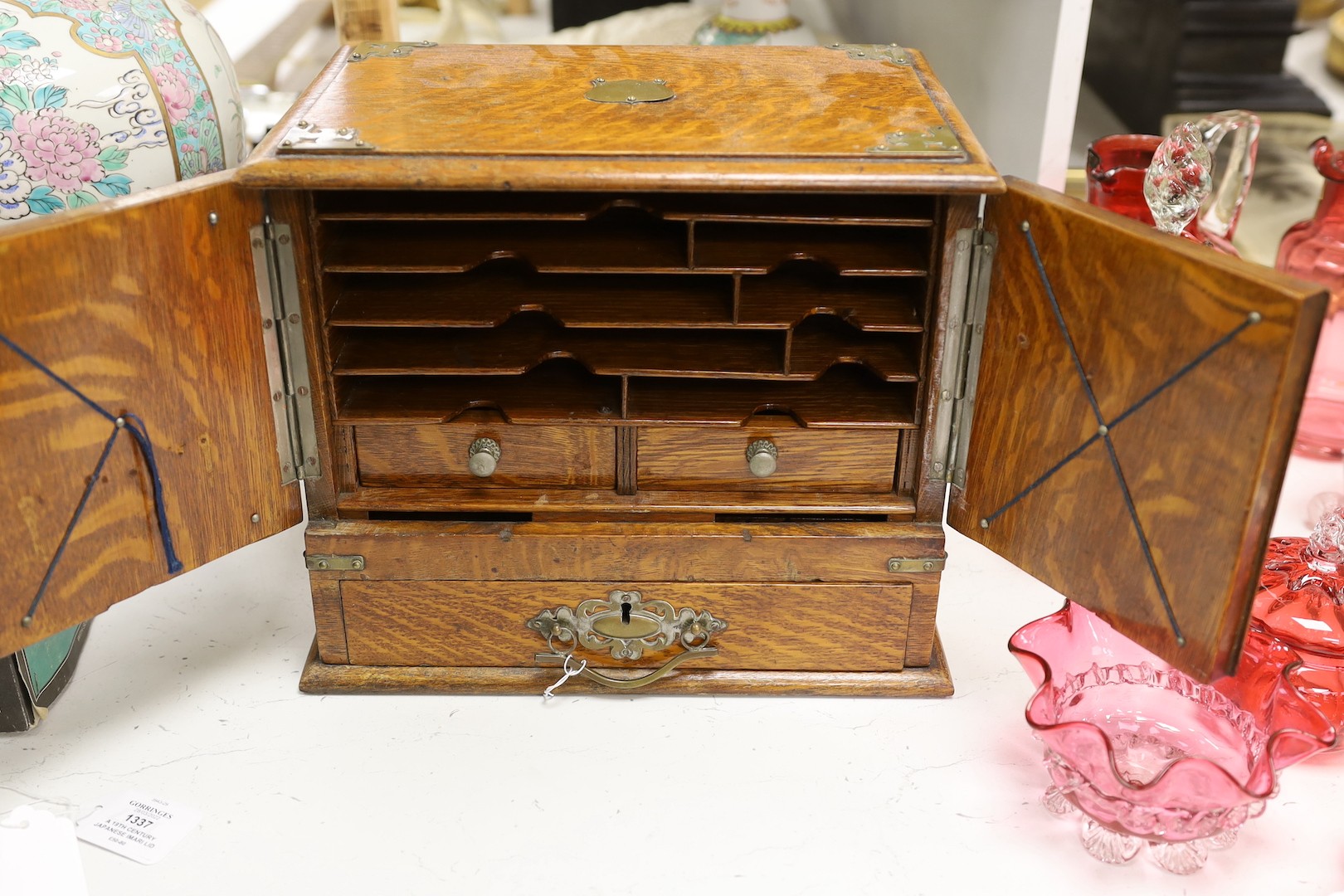 A 19th century oak stationery cabinet with brass mounts, 28.5 cms high x 33cms wide.